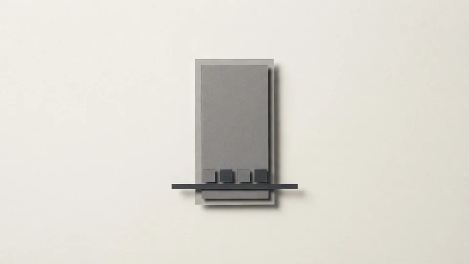 A narrow upright grey paper rectangle crossed near its base by a thin dark bar holding four tiny tiles