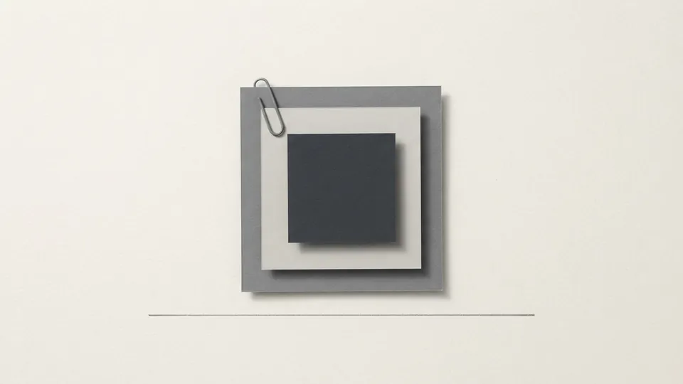 A small stack of grey and graphite paper sheets squared together and held by one paper clip, a ruled line below